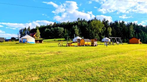 a field with tents in the middle of a field at Glamping Niebiańska Osada Jurty Dolnośląskie & SPA in Polanica-Zdrój