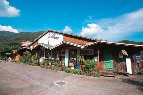 a building with a store on the side of a road at Jirisan One Night Two Days Pension in Gurye