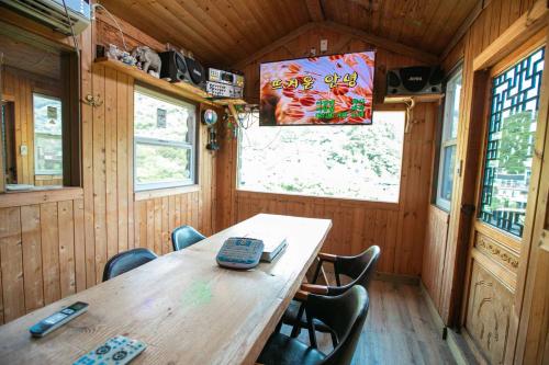 a dining room with a wooden table and chairs at Jirisan One Night Two Days Pension in Gurye