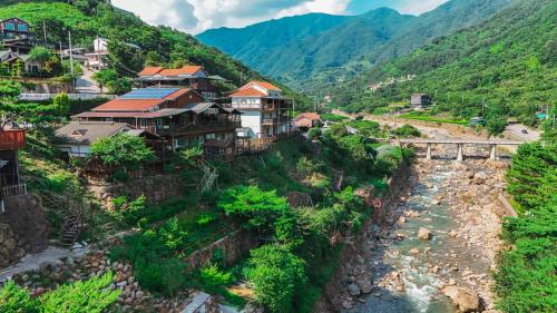 a group of houses on a hill next to a river at Jirisan One Night Two Days Pension in Gurye