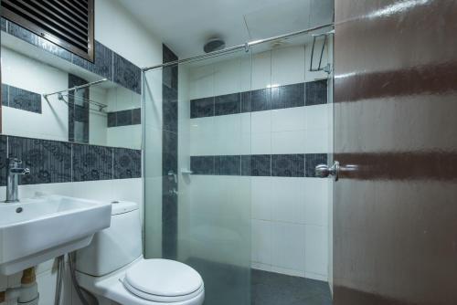 a bathroom with a toilet and a sink and a shower at Hotel Grand Orchard in Gua Sai
