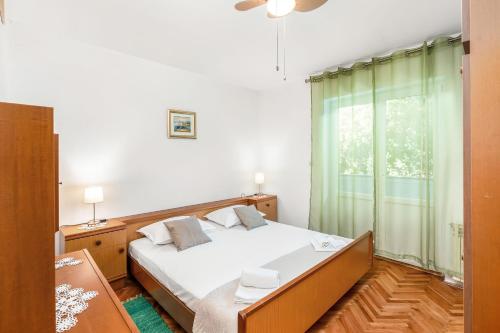 a bedroom with a bed and a window at Apartments Jelica in Pag