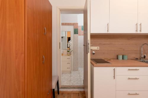 a kitchen with white cabinets and a sink at Apartments Ivana in Nin