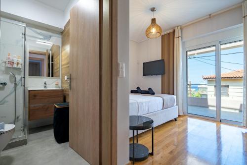1 dormitorio con cama y baño con vistas. en Villa Mareluna by Traser, en Artemida