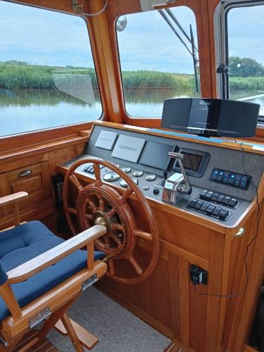 a dashboard of a boat with a steering wheel at Deluxe romantic boat in Hoogeveen