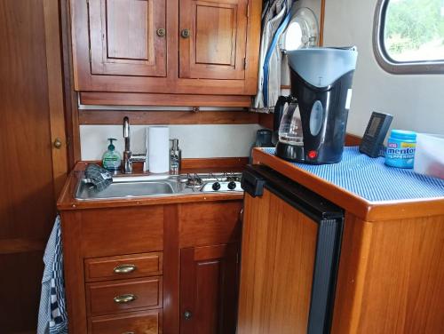 a kitchen with a sink and a coffee maker at Deluxe romantic boat in Hoogeveen