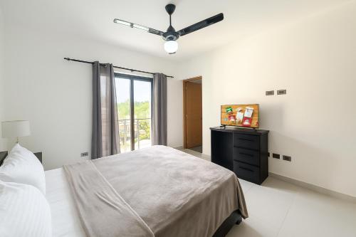 a bedroom with a bed and a ceiling fan at Fully Serviced Apartment with 24h Power, Security and Wi-Fi in Sosúa