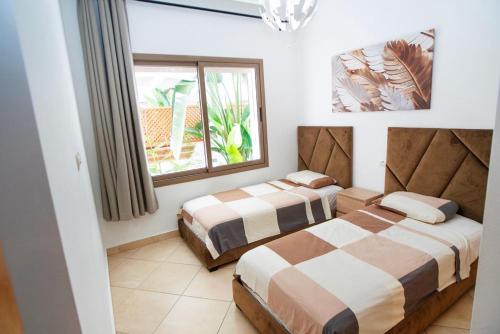 a bedroom with two beds and a window at Chez Dany à Residence Beralmar in Asilah