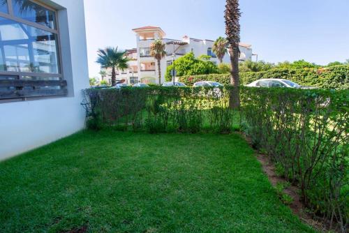 a yard with a fence and a building at Chez Dany à Residence Beralmar in Asilah