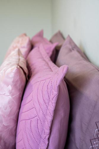 a pink pillow sitting on top of a bed at Alvorada do Lago - A melhor hospedagem de Umuarama in Umuarama