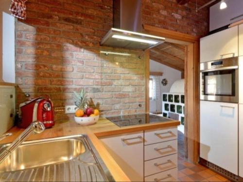 a kitchen with a brick wall and white appliances at Appartements Pöllhof in Kitzbühel