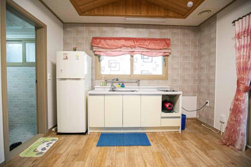 a kitchen with a white refrigerator and a window at Jirisan One Night Two Days Pension in Gurye