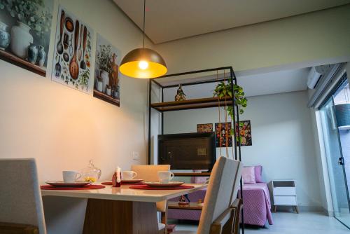 a dining room with a table and a tv at Alvorada do Lago - A melhor hospedagem de Umuarama in Umuarama