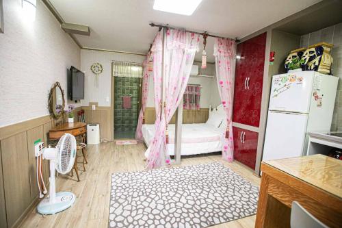 a kitchen with a bedroom with a bed and a refrigerator at Jirisan One Night Two Days Pension in Gurye