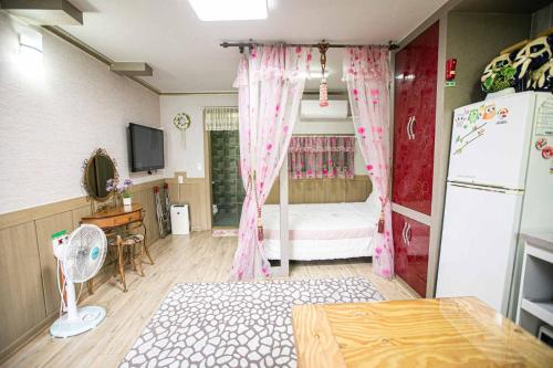a room with a bedroom with a bed with pink curtains at Jirisan One Night Two Days Pension in Gurye