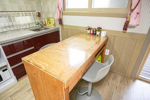 a kitchen with a wooden table and two chairs at Jirisan One Night Two Days Pension in Gurye