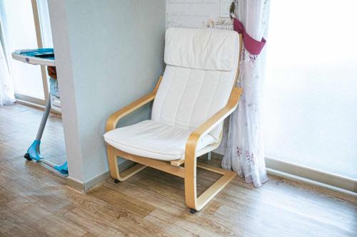 a white chair sitting in a room next to a window at Jirisan One Night Two Days Pension in Gurye