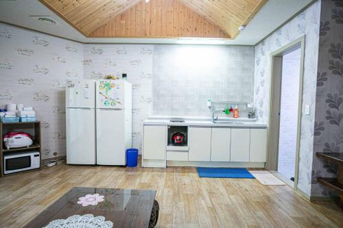 a kitchen with a white refrigerator and a sink at Jirisan One Night Two Days Pension in Gurye
