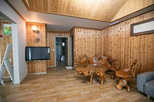a living room with a table and a tv at Jirisan One Night Two Days Pension in Gurye