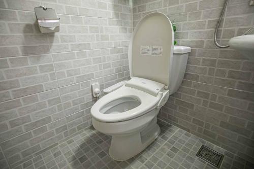 a bathroom with a white toilet in a room at Jirisan One Night Two Days Pension in Gurye