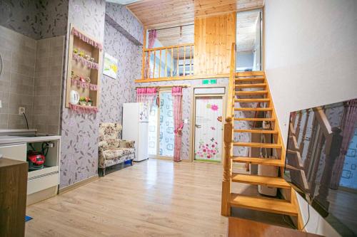 a living room with a wooden staircase in a house at Jirisan One Night Two Days Pension in Gurye