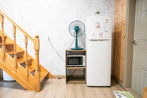 a kitchen with a refrigerator and a microwave on a table at Jirisan One Night Two Days Pension in Gurye