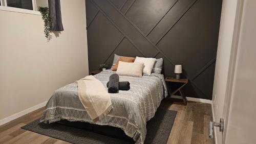 a bedroom with a bed with a gray wall at Modern Suite - Separate Entry - Self Check-In in Calgary
