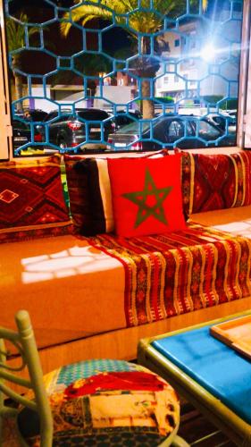 a room with a bed with a red pillow on it at Riad SULTANA lateral seaview in Saidia 