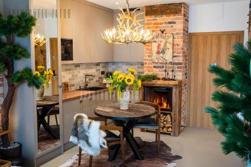cocina y comedor con mesa y chimenea en Aparthotel ZATOR Natural 56 jacuzzi, en Zator