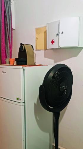 a black fan sitting on a counter next to a refrigerator at Riad SULTANA lateral seaview in Saidia 
