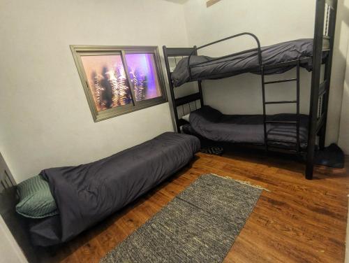 a room with two bunk beds and a rug at bali carmel zimmer & spa in Dāliyat el Karmil