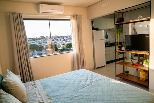 a bedroom with a bed and a large window at Alvorada do Lago - A melhor hospedagem de Umuarama in Umuarama