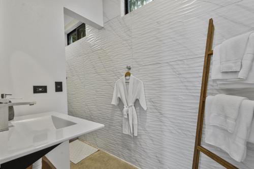 a bathroom with a robe hanging on a wall at L'Avventura in Tamarindo