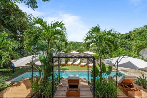 a pool with a wooden deck next to a resort at L'Avventura in Tamarindo