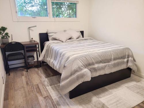 a bedroom with a bed and a table and a window at Spacious 3-Bedroom Home. in Regina