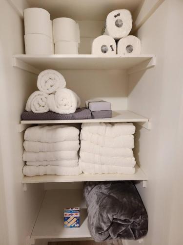 a closet filled with towels and toilet paper at Spacious 3-Bedroom Home. in Regina