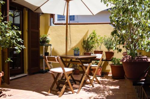 patio ze stołem, krzesłami i parasolem w obiekcie Pimpioxelli w mieście Quartucciu