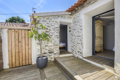 a house with a potted plant on a wooden deck at Maison - Spa - Parking - Jardin - 7p in Vertou
