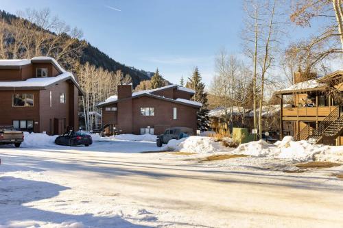 a snow covered street in a town with buildings at Cozy Modern 2-Bedroom Condo Between Vail and BC in Avon