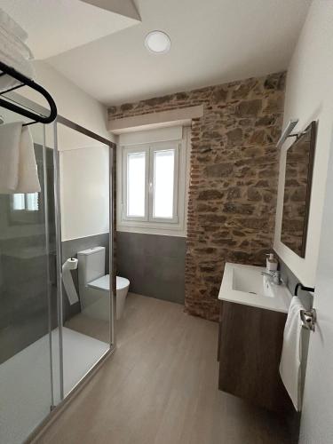 ein Badezimmer mit Waschbecken und Toilette und einem Fenster in der Unterkunft Apartamentos Puerta los Castañares B in Constantina