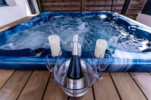 a bottle of wine and two wine glasses in a hot tub at Maison - Spa - Parking - Jardin - 7p in Vertou