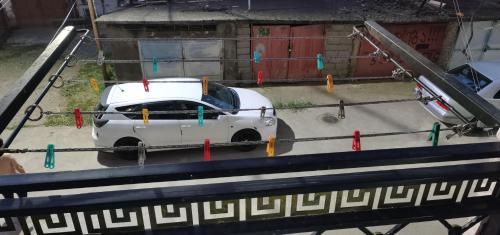 Biały samochód stoi na parkingu w obiekcie TEMO'S APARTAMENT IN KUTAISI w Kutaisi