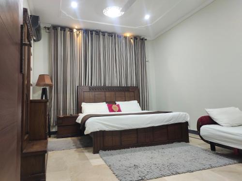 a bedroom with two beds and a window at Vision 2 Islamabad in Islamabad