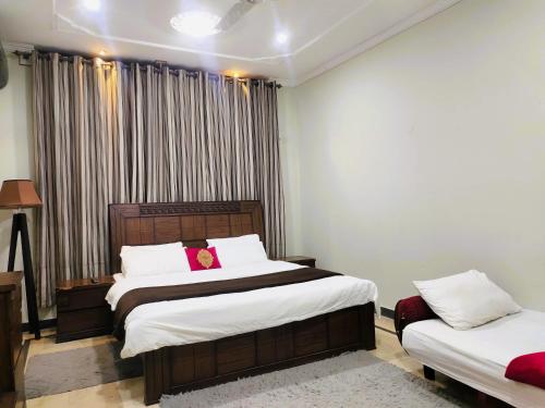 a bedroom with two beds and a window at Vision 2 Islamabad in Islamabad