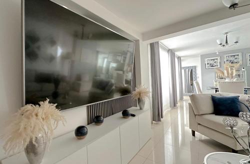 a living room with a couch and a large screen at LUXURY Arequipa in Arequipa