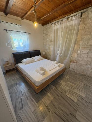 a bedroom with a large bed and a stone wall at Casa Maximos in Santa Maria