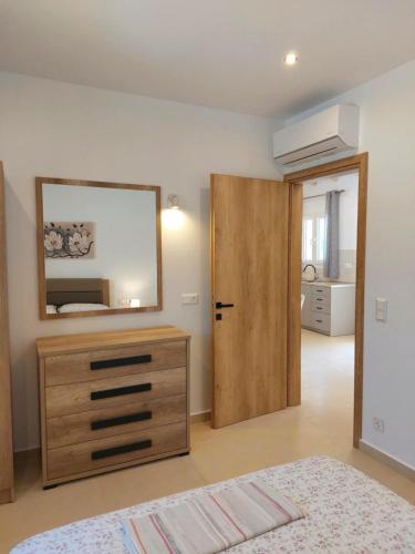 a bedroom with a wooden dresser and a mirror at Villa Eleni Apartment no3 in Agios Gordios