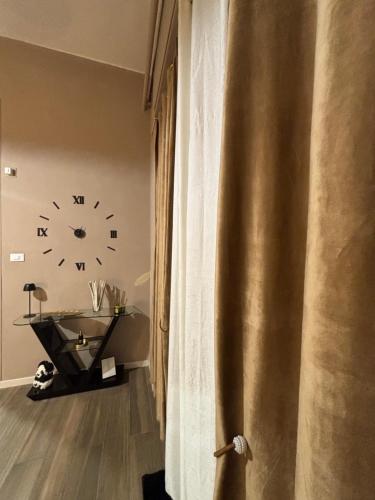 a room with a clock on the wall and a table at Dimora Camilla apartment intero appartamento in Foggia