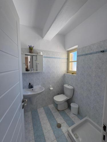 a bathroom with a white toilet and a sink at Casa Maximos in Santa Maria