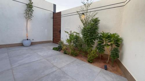 a courtyard with plants on the side of a building at شاليهات العزيزية الفندقية in Buraydah